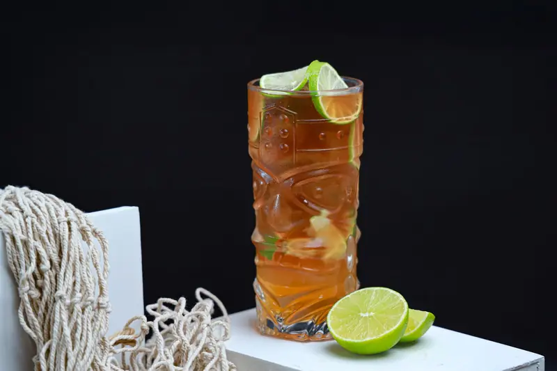 A vibrant tiki glass of lime and mint iced tea, perfect for summer refreshment