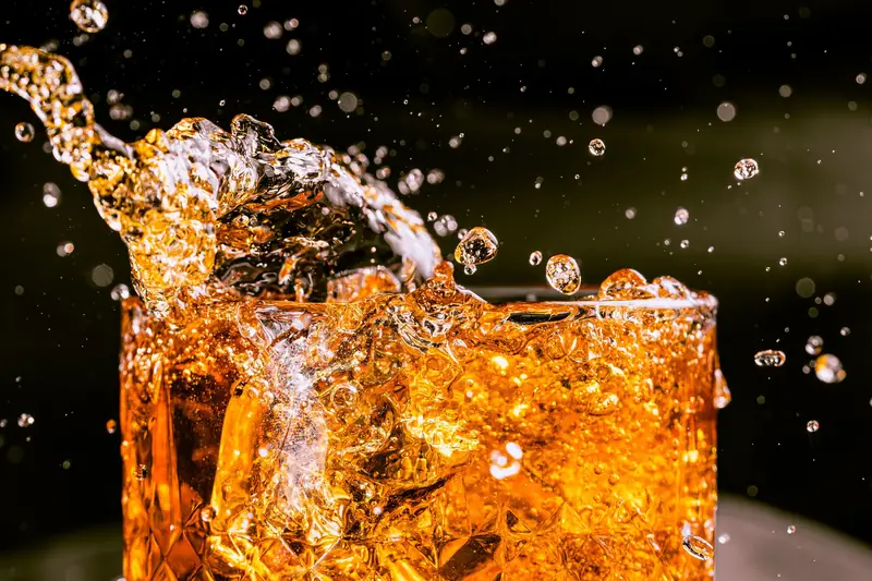 Close-up of whiskey splashing in a glass, capturing motion and texture